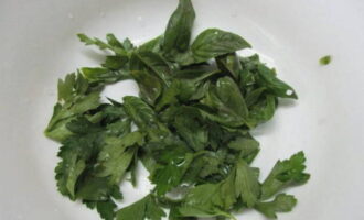 В посуду для салата поместите промытые и обсушенные листья базилика и петрушки.