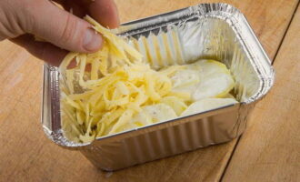 Форму для запекания смажьте растительным маслом и выложите слои картофеля и сыра, чередуя их. Поливаем все  сливками.
