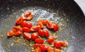 Сковородку ставим на умеренный огонь и растапливаем масло, после выкладываем нарезанные помидоры и тушим на протяжении нескольких минут.