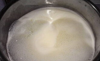 Варите молоко на среднем огне, постоянно помешивая, 20 минут. Постепенно масса приобретет желтоватый цвет.