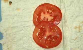На каждый кусок лаваша положите по два кружка помидора.