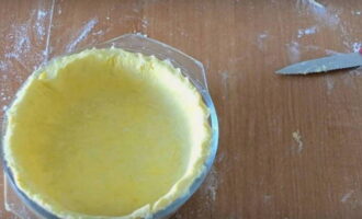 Охлажденное тесто раскатываем в тонкую лепешку и укладываем его в форму для запекания, сформировав по краю бортики.