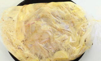 Поместите курицу и картофель в рукав для запекания, закрепите его края. Выложите заготовку в форму с высокими бортиками и поместите в духовку, разогретую до 180 градусов. Запекайте блюдо 60-80 минут.