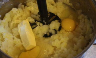 В это время отвариваем очищенный картофель в подсоленной воде и разминаем с добавлением яиц и сливочного масла в пюре. 