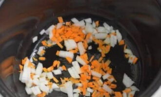Лук и морковь очищаем и мелко нарезаем. Мультиварку разогреваем в режиме «Жарка». Вливаем немного растительного масла в чашу и высыпаем лук с морковью. Обжариваем минут пять-семь при помешивании.