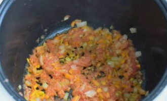Добавляем натертые на терке томаты без кожицы, перемешиваем и продолжаем обжаривать еще семь-восемь минут.