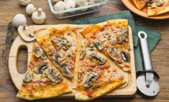 Готовую грибную пиццу сбрызгиваем оливковым маслом, делим на порции и подаем к столу.
