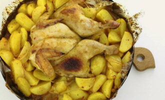 Подавайте запеченную курицу с картофелем в горячем виде на общем блюде.