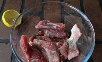 Маринуем мясо: свинину нарезаем кусочками, посыпаем солью и черным перцем, сбрызгиваем лимонным соком – перемешиваем и оставляем на 15 минут для пропитки.