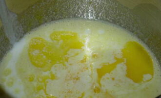 В тарелке с высокими бортиками соединяем следующие ингредиенты: яйца, сахар, соль, сливочное масло (растопленное), кефир и ванилин. 