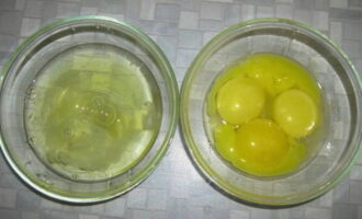 Куриные яйца разделите на желтки и белки и поместите их в две отдельные пиалы или глубокие миски.