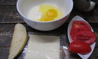 Подготавливаем продукты: яйца взбиваем с добавлением небольшого количества сметаны, воды и соли. Помидоры и хлеб нарезаем ломтиками.