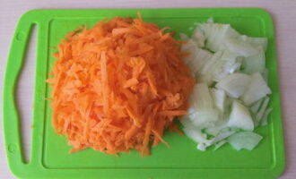 Очищаем овощи. Луковицу разрезаем пополам, а затем нарезаем полукольцами. Полукольца измельчаем пополам. Натираем вымытую морковь на терке.