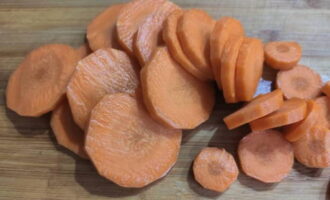 Крупную морковь очищаем от кожицы и нарезаем достаточно толстыми колечками.