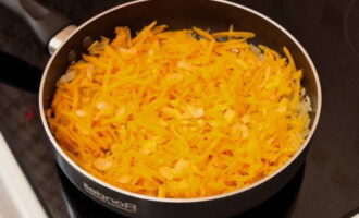 На сковороде разогреваем небольшое количество растительного масла и слегка обжариваем на нём репчатый лук. Затем добавляем туда морковь и готовим до мягкости овощей.