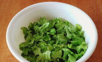 Чистый листовой салат рвем руками на небольшие сегменты и кладем в салатник.
