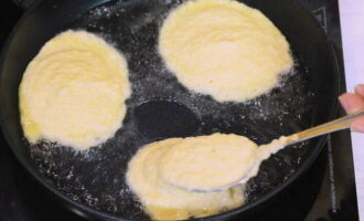 В сковородке с толстым дном разогреваем растительное масло и столовой ложкой выкладываем картофельную массу, формируя оладьи.