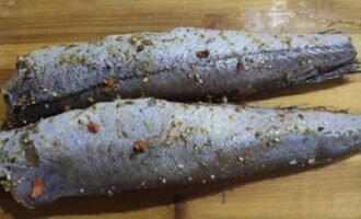 Потрошеные тушки хека старательно натираем солью и приправой для рыбы.