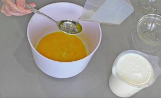 Для приготовления пирога сначала замешивается кефирное тесто. В отдельную посуду разбиваются два куриных яйца, насыпается к ним соль с сахаром и добавляется растительное масло.
