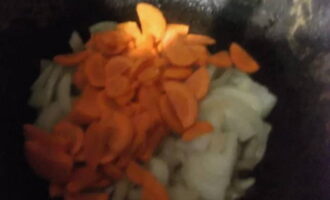 В кастрюле с толстым дном растапливаем сало и вынимаем румяные кусочки, в полученном жиру слегка обжариваем баранину и перекладываем ее в отдельную посуду. После, в том же «котелке» пассеруем полукольца лука и кружки моркови до мягкости.