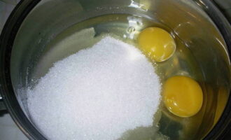 В посуде с высокими бортиками тщательно перетираем два куриных яйца со стаканом сахара.