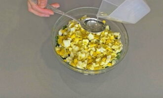 В отдельной посуде нарезанные лук с яйцом посыпаются солью, заправляются растительным малом, чтобы начинка в пироге не рассыпалась, и все хорошо ложкой перемешивается.