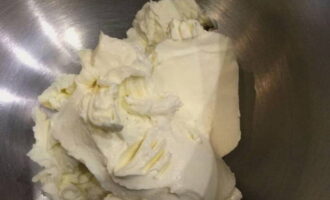 В глубокую ёмкость, в которой будем взбивать крем, выкладываем сливочный творожный сыр. Для получения качественного крема он должен быть очень холодный. Важно случайно не взять плавленый сыр.