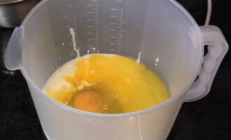 Мука для пирога просеивается через сито и перемешивается с разрыхлителем и щепоткой соли. В посуду для замеса теста наливается теплый кефир. К нему разбивается одно яйцо и добавляется растопленный в микроволновке маргарин. Эти ингредиенты перемешиваются с помощью миксера или венчиком.