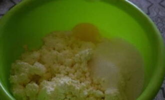 В глубокой тарелке смешиваем творог, яйцо и сахарный песок.