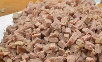 Заранее отваривается кусок свинины в бульоне с добавлением соли и любых специй. Отваренная свинина нарезается небольшими кубиками. Бульон оставляется.