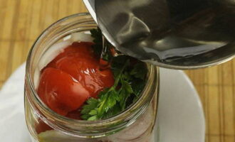 Поверх помидоров уложить остальную зелень. Залить овощи в банке крутым кипятком, прикрыть крышкой и оставить на 15 минут.