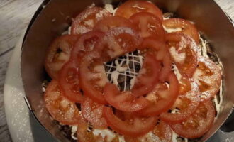 Пятым слоем выкладываются по кругу нарезанные помидоры., присыпаем их солью и молотым перцем по вкусу.