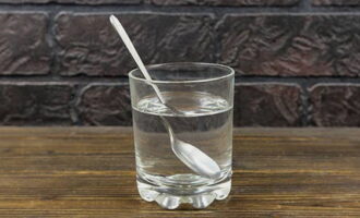 В стакан наберите 150 миллилитров ледяной воды. Налейте столовую ложку уксуса и размешайте до однородности.