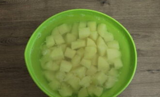 Картофель помойте от песка, овощечисткой снимите кожицу или очистите ножом. Нарежьте кубиком. Сложите в миску и залейте холодной водой.