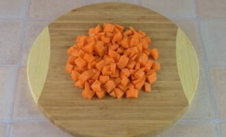 Морковку промойте. Кожуру снимите овощечисткой. Очищенную морковку нарежьте кубиком. Метод нарезки определите самостоятельно. Смысл в том, чтобы нарезка всех овощей была одинаковой.