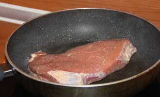 После этого говяжий продукт перекладываем в сковороду и жарим с обеих сторон по четыре минуты.