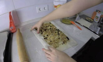На пласты теста ровным слоем выложить яблочную начинку и края без масла завернуть на начинку.