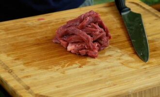 Нарезаем подготовленное мясо тонкой соломкой.