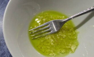Измельчаем чеснок и перемешиваем его с оливковым маслом в глубокой тарелке.