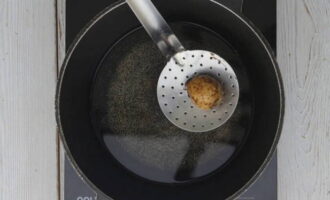 Казан поставьте на плиту, установив средний нагрев и раскалите. Налейте масло без запаха. После чего аккуратно погрузите целую луковицу и зарумяньте. С помощью шумовки извлеките ее, она больше не понадобится.
