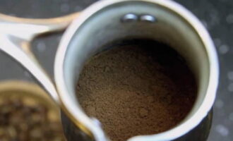 Молотый кофе пересыпьте в турку и слегка постучите о стол, чтобы он равномерно распределился.