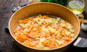 Толстостенную сковородку, в идеале чугунную, поставьте на плиту, установив средний нагрев и раскалите. Налейте масло без запаха. После чего аккуратно погрузите луковицу и морковку, зарумяньте овощи. Когда овощи станут мягкими, закиньте свинину и обжарьте до золотистости.