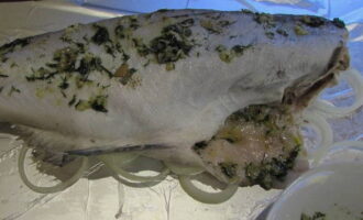 Подготовленную рыбу кладем на противень с фольгой. Обмазываем ее ароматной заготовкой из масла и специй.