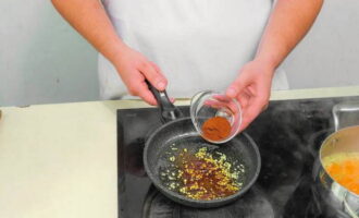 Измельчаем оставшийся корень имбиря. Обжариваем продукт на сковороде с оливковым маслом. Дополняем копченой молотой паприкой и готовим, помешивая, две минуты.