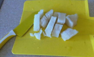 Замороженное филе минтая разрежьте на части.