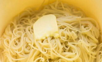 Переложите спагетти в посуду и сдобрите сливочным маслом.