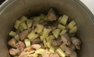 Картофель ополосните под водой и почистите от кожицы овощечисткой. Нарежьте, как вам нравится, и сложите в казан. Время от времени помешивая содержимое, обжарьте.