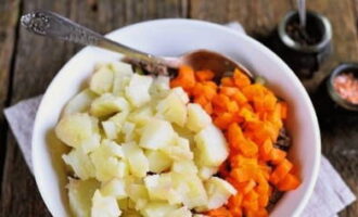 Отварной картофель и морковку освободите от кожицы и нарубите кубиком. Добавьте в салатник.