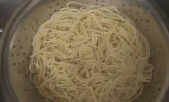 Спагетти откиньте на дуршлаг и промойте под краном, оставьте, чтобы лишняя жидкость стекла.