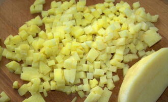 Картошку небольшого размера хорошенько вымойте. Я использую щетку для мытья овощей. Почистите овощечисткой. Почищенные корнеплоды разрежьте на мелкие кубики.